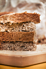 detail of brown bread, closeup of Sliced whole wheat food on a wooden chopping board (vertical picture)