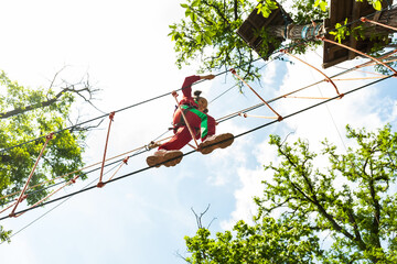 Girl climbing in high rope course enjoying the adventure