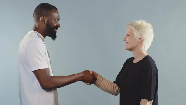 Close up black man and white woman shake hands stop racism all people are equal togetherness symbol tolerance multiracial peace interracial friendship anti-racism slow motion