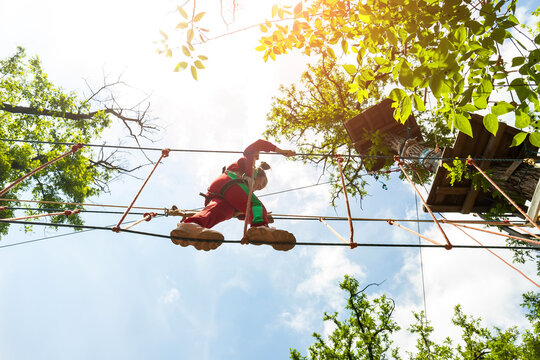 Girl climbing in high rope course enjoying the adventure