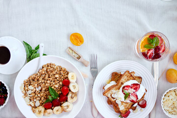 Fresh and bright continental breakfast table, abundance healthy meal variety crunch cereal, french toast, fruits, lemonade on  table served, top view, flat lay, copy space, frame..