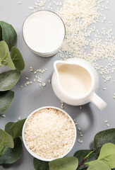 Vegan Rice milk with rice grains on gray background. Copy space, top view