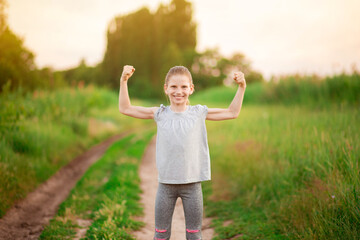 Child cute girl show biceps gesture of power and strength outdoor. Feel so powerful. Girls rules...