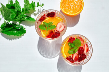Summer cocktail with strawberry, orange and mint in glass