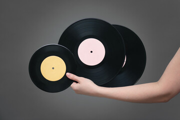 A retro vinyl records in female hand on a gray background.