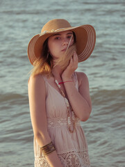 Woman wearing ethnic dress. Carefree boho girl in white summer dress walking on beach. Happy young woman relaxing on seashore. Summer vacation. Mindfulness and relaxation. Lifestyle