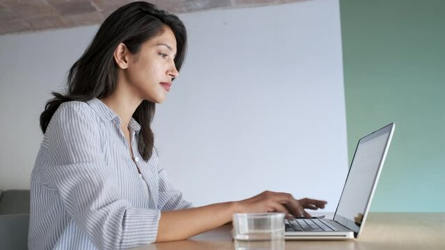Video of elegant young business woman working with her laptop in the office.