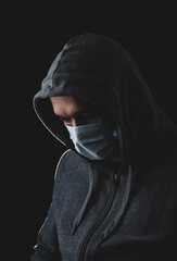 man in a medical mask on a black background, protection against coronavirus