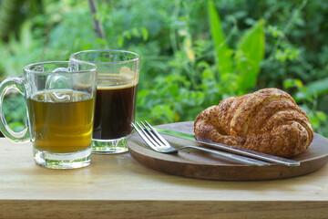 Thai Black Coffee and hot Tea with croissant bread on  Wooden Bar