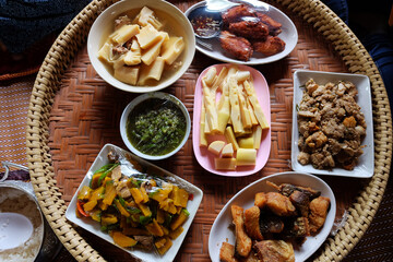 Homemade cooking for Boiled bamboo shoots, chili paste, Deep fried Snapper with fish sauce and Fried Pumpkin with Eggs on Woven tray is tradition Thai local food.