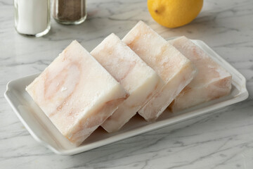 Dish with frozen cod fish fillets to thaw
