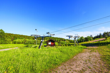 Beautiful landscape view on summer day. Cableway construction slalom ski lift on hill peak on blue sky background. Sweden. Europe.