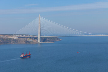 Close up shot of Yavuz Sultan Selim Bridge in Istanbul. Third and newest bridge in Istanbul. A ship is passing under the bridge.