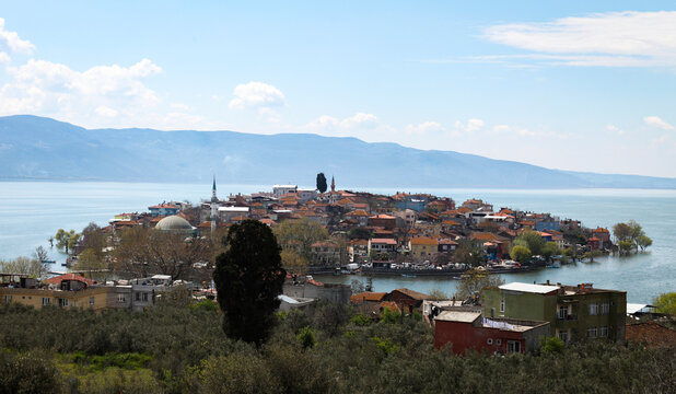 Aerial view of Golyazi peninsula on a sunny day, in Bursa, Turkey. Little cute peninsula hosts many houses and cafes. City of Bursa is in the background in a silhouette.