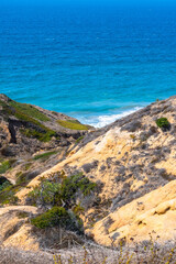 Fototapeta na wymiar San Diego, California. Sandstone cliffs in desert mountain landscape by the ocean. Torrey Pines State Reserve Park hike trails in Lo Jolla, on warm sunny dry summer day.