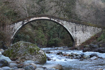 An old famous stone bridge with the river running underneath in Rize, Turkey.