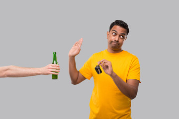 Indian man Saying No to Beer bottle Holding car Keys. Dont Drink and Drive Concept. Man Doesnt...