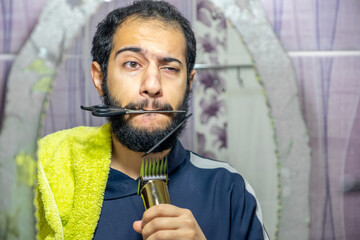 Arabic muslim man cutting his own hair by himself