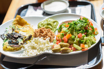 Israeli breakfast plate found in every cafe in Israel, this plate has everything that is good eggs per the diners request, different cheeses and condiments, fresh Israeli salad and a bread basket.