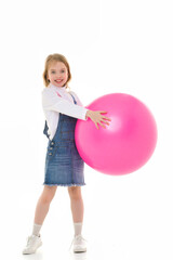 Little girl plays with a big ball for fitness