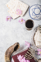 Metal plate with matzah or matza, Kiddush Cup, Shofar horn on a light  background presented as a...