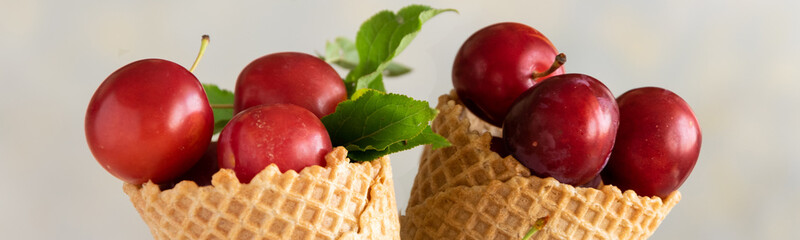 Fresh raw plums in ice cream cones, healthy sweet refreshing food