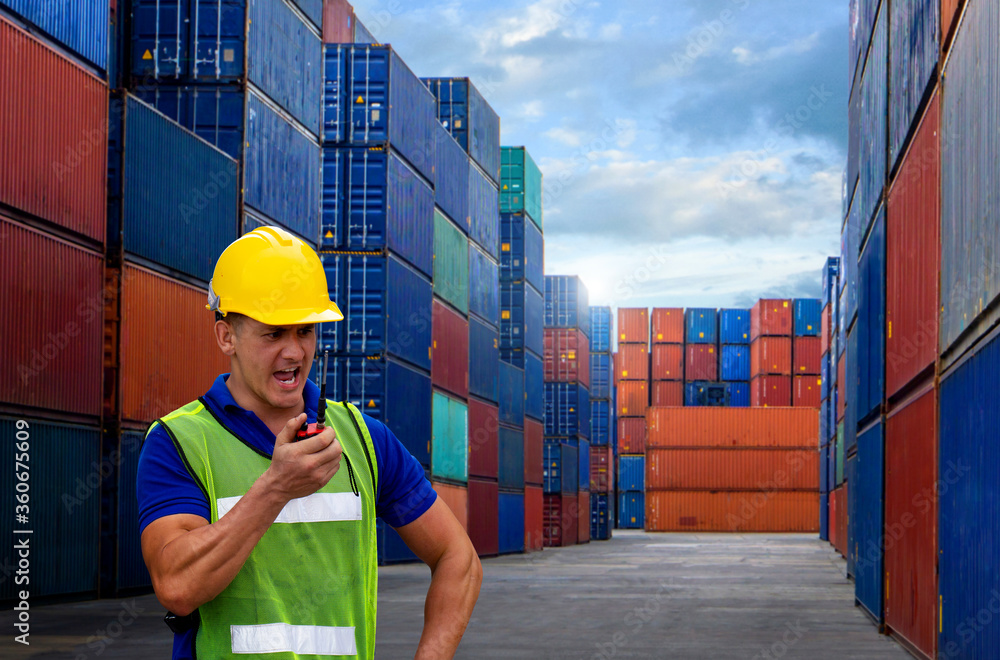 Fototapete industrial worker is controlling container loading in import-export business.