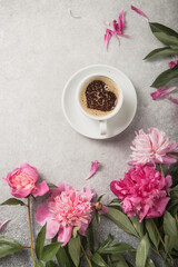 Note book, peonies and cup of coffee on light concrete backgrounds