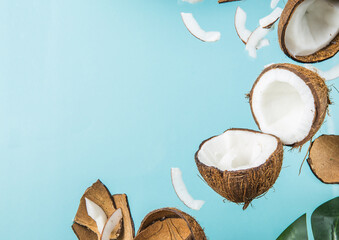 Halves of coconut, open  cut in half isolated on blue background. Coconut pulp is very healthy wholesome food. Top view, copy space, place for text.