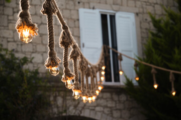 Decorative garden lighting design made with bulbs and thick rope