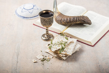 Passover, the Feast of Unleavened Bread, matzah  and  Kosher red wine glasses shofar (horn) with religious holy prayer book on table