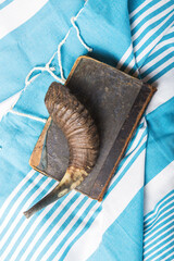 Jewish traditional objects,  Tallit, Prayer book shofar -horn on blue jewish prayer shawl.  Copy space for text. View from above