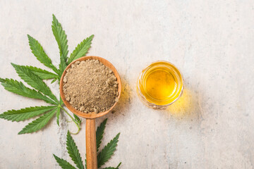Fototapeta na wymiar Hemp flour in wooden spoon and hemp essential oil. Copy space. CBD cannabis.