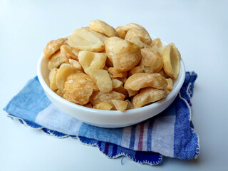 Aleurites moluccanus or Indonesian Candlenuts called Kemiri, inside a bowl, isolated in white background