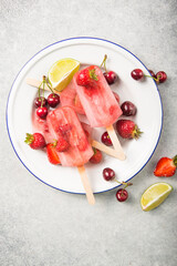 Berry Popsicle with wooden sticks on concrete counter. Homemade Strawberry Frozen Fruit Bars