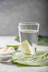 Collagen Powder and glass of water with  slice of Lime; Vitamin C . Collagen supplements may improve skin health by reducing wrinkles and dryness.