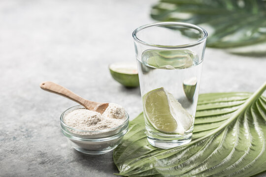 Collagen Powder and glass of water with  slice of Lime; Vitamin C . Collagen supplements may improve skin health by reducing wrinkles and dryness.