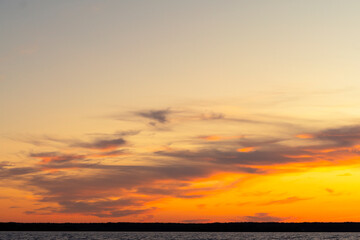 Water surface. View of a Sunset sky background. Dramatic gold sunset sky with evening sky clouds over the sea. View of a Crystal clear sea water texture. Landscape. Small waves. Water reflection