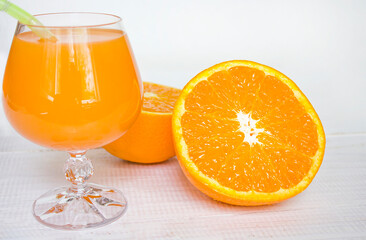fruit juice in a glass. orange juice and oranges on a white wooden background. vitamin juice....