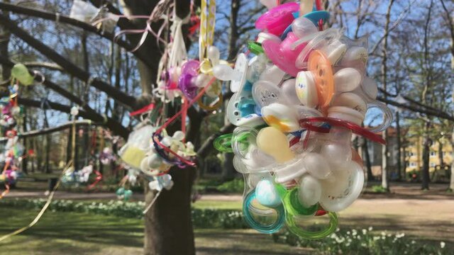 pacifiers hanging on a tree branch in the park Malmo Sweden