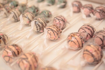 Pink cake pops drizzled with dark chocolate 