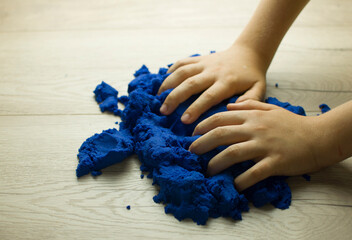 Child playing with kinetic sand.
