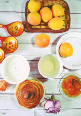 Food still life with Icelandic thick cultured milk called skyr, twist of bread, apricot jam, fresh apricots, green tea cup, wooden spoons as concept for healthy breakfast. Organic diet meal. 