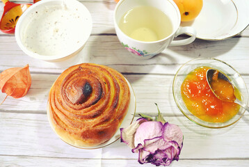 Food still life with Icelandic thick cultured milk called skyr, twist of bread, apricot jam, fresh apricots, green tea cup for healthy breakfast. Organic diet meal. Weight control. 
