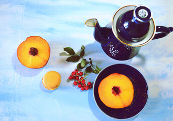 Food still life with peach slices, peach macaron, ash berries (Sorbus in Latin) and indigo blue jar...