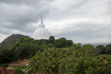 Fototapeta premium Mihintale, Sri Lanka - CIRCA 2018: Big white Buddha statue against blue sky in Mihintale, the cradle of buddhism at Sri Lanka
