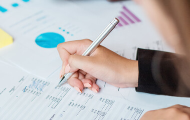 Hand of business woman pointing document data graph and chart with pen, marketing and investment, report of statistics profit for financial, economic and growth of finance, management and planning.