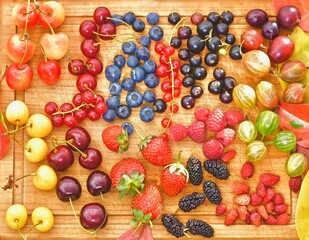 a variety of fresh berries on a wooden background