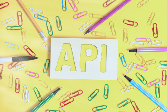 Conceptual hand writing showing Api. Concept meaning set of routines, protocols, and tools for building software applications Flat lay above empty paper with pencils and paper clips