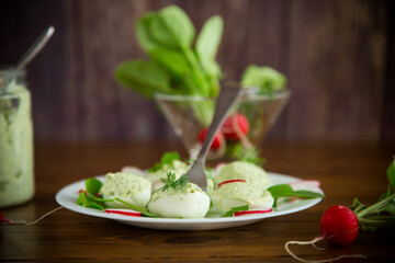 boiled stuffed eggs with green cheese filling with arugula leaves and radish